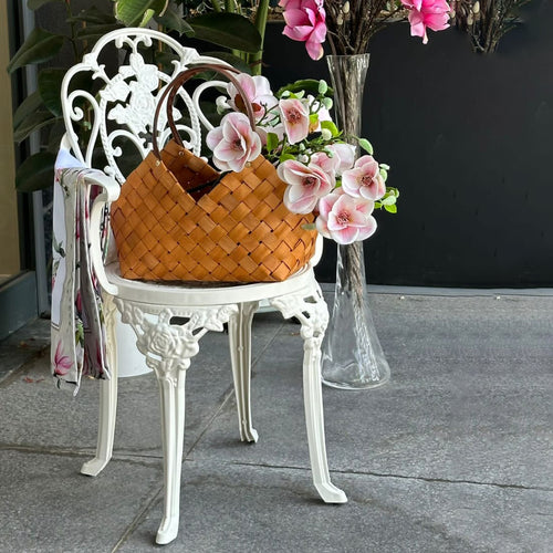 Scaun exterior alb SICILY fotografiat cu floare, evidențiind designul ergonomic, materialul durabil și structura rezistentă la intemperii. Ideal pentru spații exterioare precum terase, grădini și cafenele.